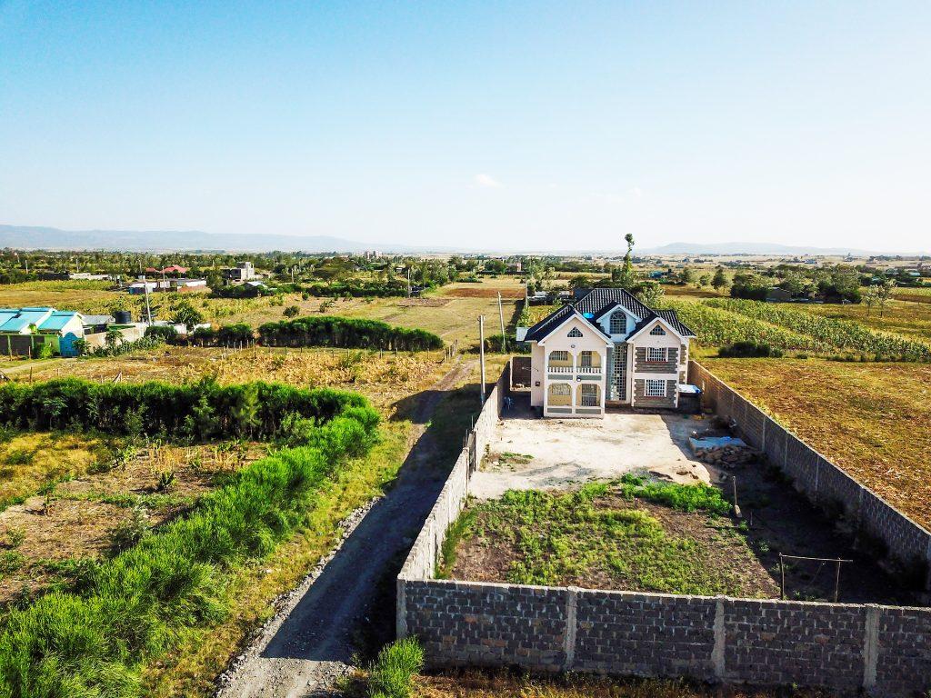 Aerial view of a newly built multi-storey maisonette on a standalone walled plot, showcasing prime rural-suburban land acquisition and residential compound developments in Kenya.